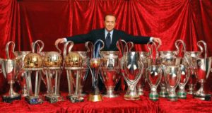 Una immagine di Silvio Berlusconi con i trofei conquistati dall'AC Milan nei 30 anni di gestione aziendale (foto tratta dal web)